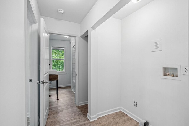 laundry area featuring washer hookup, wood finished floors, and baseboards