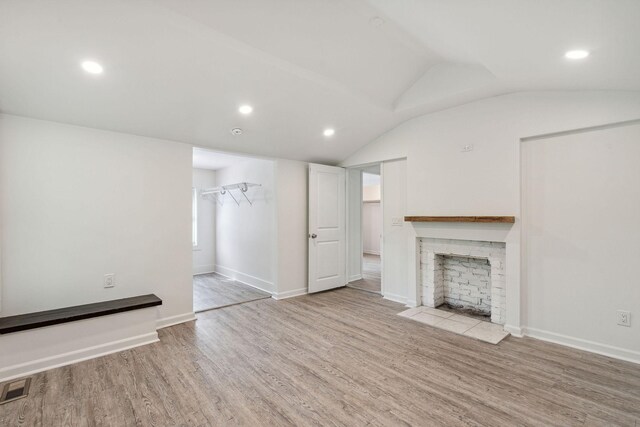 unfurnished living room with wood finished floors, a fireplace, vaulted ceiling, recessed lighting, and baseboards