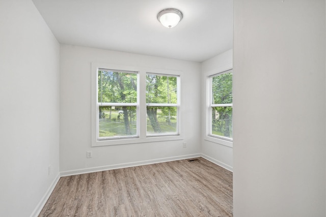 spare room with wood finished floors and baseboards
