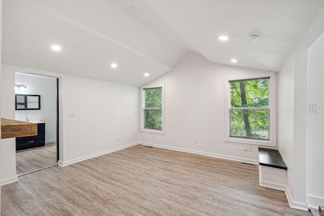 unfurnished bedroom with light wood-style floors, multiple windows, vaulted ceiling, baseboards, and recessed lighting
