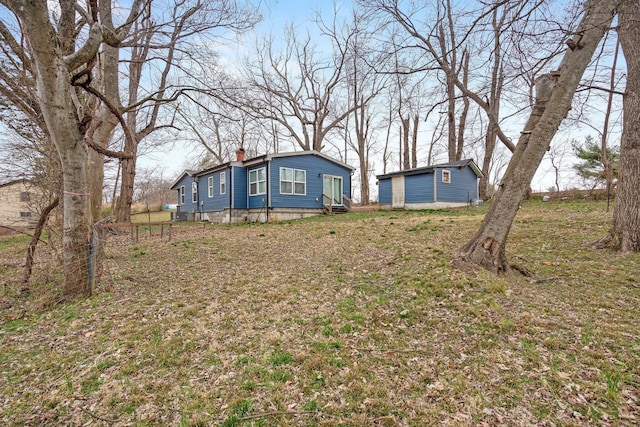 view of yard with entry steps and an outbuilding
