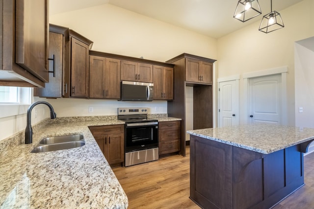 1203 Goose Dr, Springfield, TN 37172 - kitchen featuring stainless steel appliances, a sink, light wood-style floors, a kitchen island, and light stone counters