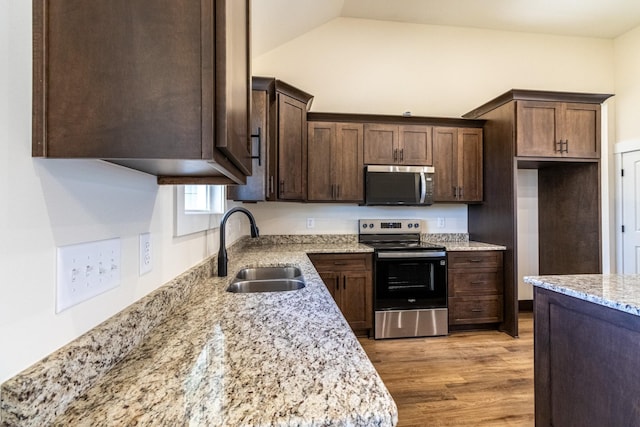 1203 Goose Dr, Springfield, TN 37172 - kitchen featuring stainless steel appliances, a sink, light wood-style floors, light stone countertops, and dark brown cabinets