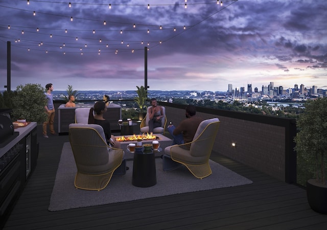 deck at dusk with a fire pit and a view of skyline