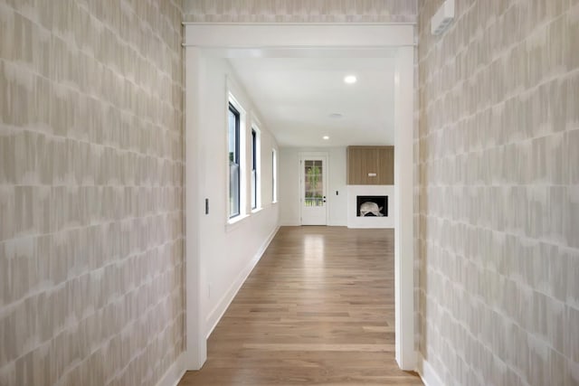 corridor with wood finished floors, baseboards, and recessed lighting