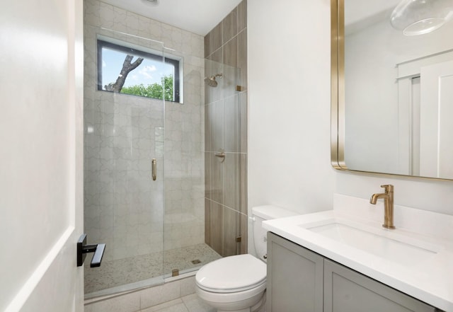 bathroom with a stall shower, toilet, and vanity