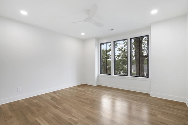 empty room with baseboards, ceiling fan, recessed lighting, and wood finished floors