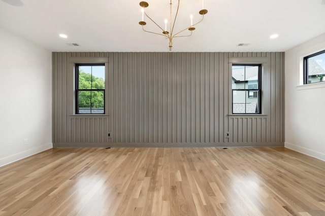 spare room featuring light wood-style floors, a chandelier, baseboards, and recessed lighting