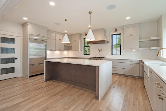kitchen featuring open shelves, built in refrigerator, custom exhaust hood, tasteful backsplash, and light wood-type flooring