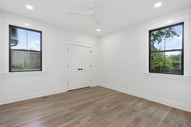 empty room with light wood-type flooring, baseboards, a ceiling fan, and recessed lighting