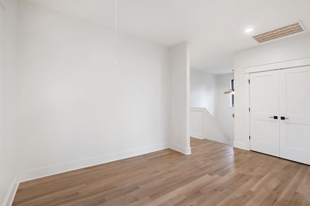 empty room featuring light wood finished floors, baseboards, and recessed lighting