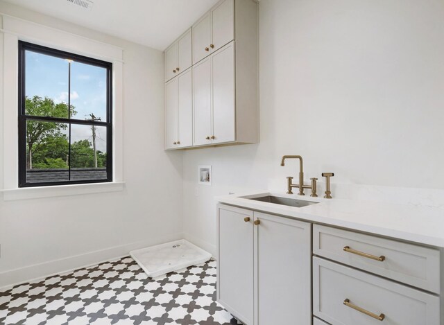 laundry area featuring cabinet space, tile patterned floors, baseboards, and washer hookup