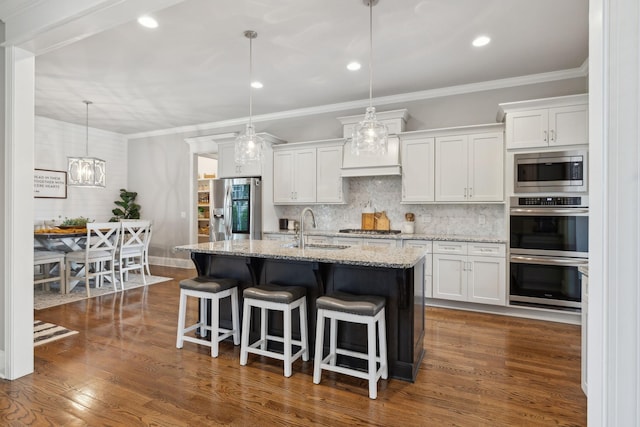 1567 Bunbury Dr, Thompsons Station, TN 37179 - kitchen featuring appliances with stainless steel finishes, a sink, white cabinetry, backsplash, and an island with sink