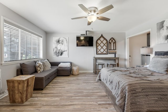 bedroom featuring light wood finished floors, baseboards, and ceiling fan