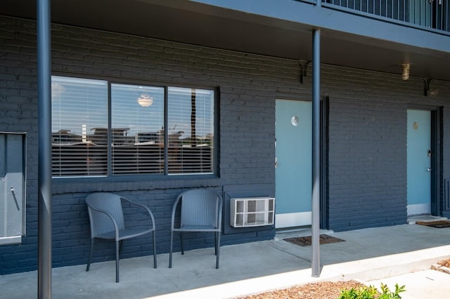 property entrance featuring brick siding and a patio area