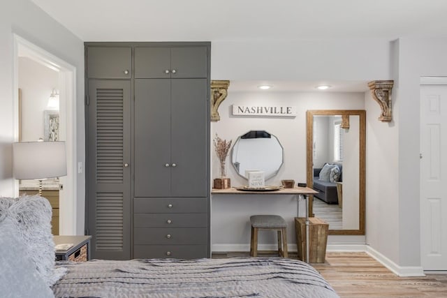 bedroom featuring wood finished floors, baseboards, a closet, and recessed lighting