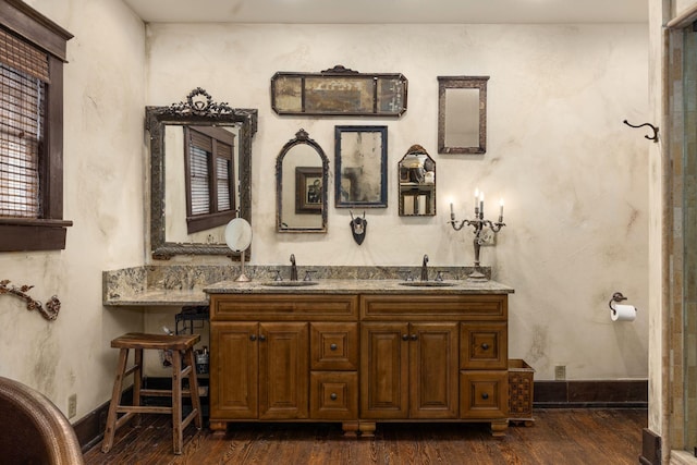 bathroom with wood finished floors and double vanity