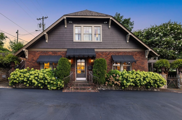 craftsman-style house featuring brick siding and a standing seam roof