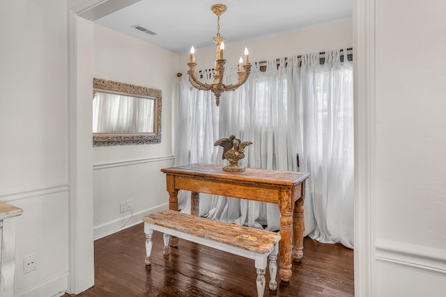 dining room featuring a chandelier, wood finished floors, and baseboards