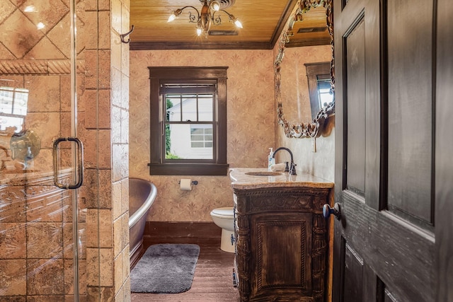 bathroom featuring ornamental molding, wood finished floors, baseboards, toilet, and a freestanding tub