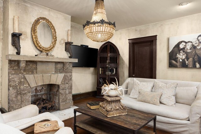 living area with wood finished floors, a fireplace, and a chandelier