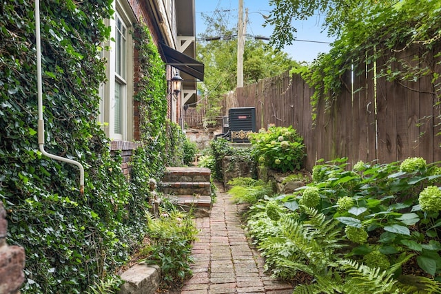 view of yard featuring fence and central AC unit