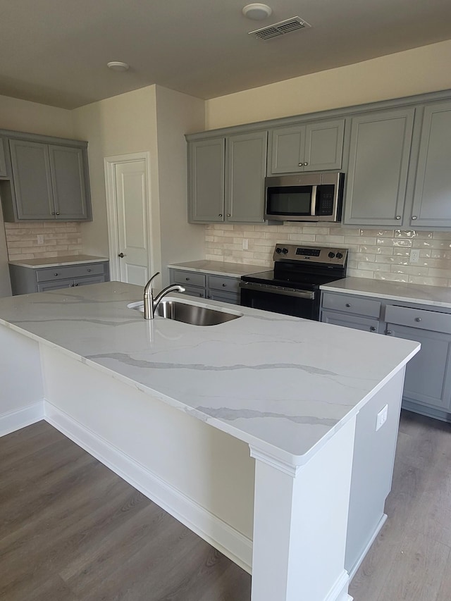 116 Holly Rdg, Antioch, TN 37013 - kitchen with stainless steel appliances, gray cabinets, light stone counters, and wood finished floors