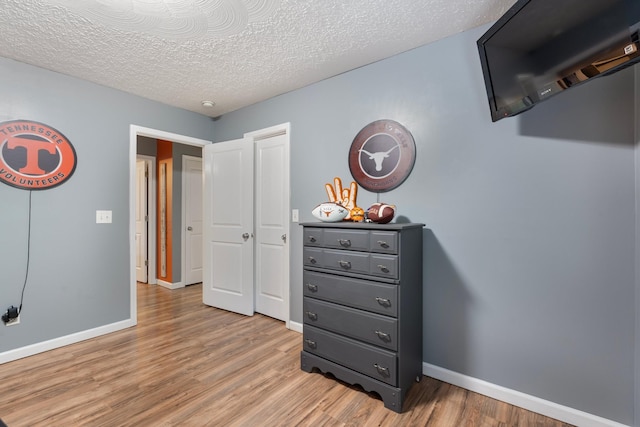 1056 Simms Heights Rd, Kingston Springs, TN 37082 - bedroom featuring light wood-type flooring, baseboards, and a textured ceiling