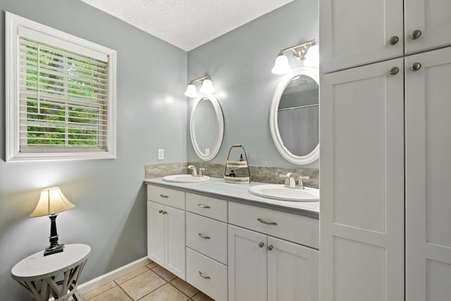 1056 Simms Heights Rd, Kingston Springs, TN 37082 - full bathroom with a textured ceiling, tile patterned flooring, double vanity, and baseboards