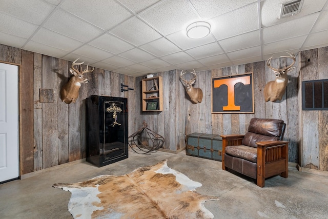 1056 Simms Heights Rd, Kingston Springs, TN 37082 - living area featuring a paneled ceiling, unfinished concrete floors, wood walls, and baseboards