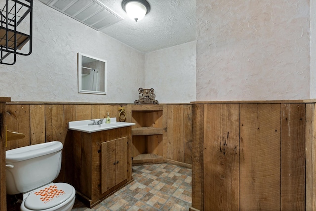 1056 Simms Heights Rd, Kingston Springs, TN 37082 - full bathroom with toilet, a textured wall, wood walls, a textured ceiling, and vanity