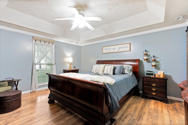1056 Simms Heights Rd, Kingston Springs, TN 37082 - bedroom featuring a tray ceiling, wood finished floors, a textured ceiling, baseboards, and crown molding