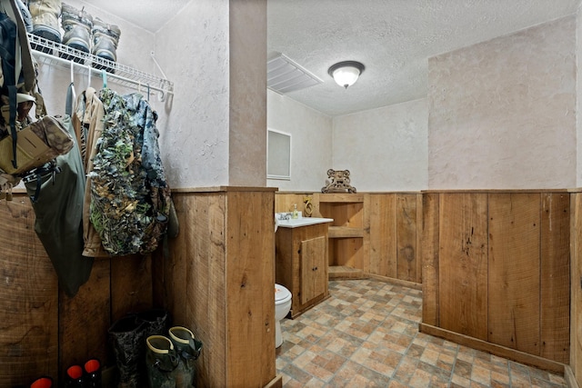 1056 Simms Heights Rd, Kingston Springs, TN 37082 - bathroom featuring brick floors, toilet, a textured wall, vanity, and wood walls