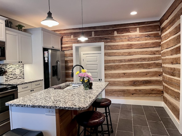 219 Garner St, Springfield, TN 37172 - kitchen with stainless steel appliances, wooden walls, a sink, white cabinets, and a kitchen bar