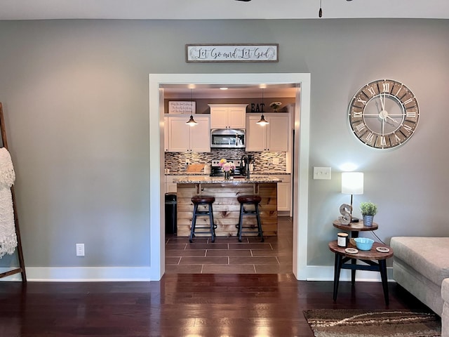 219 Garner St, Springfield, TN 37172 - bar area with stainless steel appliances, dark wood-style flooring, baseboards, decorative backsplash, and a ceiling fan