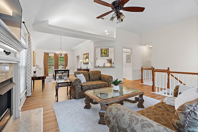313 Red Feather Ln, Brentwood, TN 37027 - living room with light wood-style flooring, a fireplace, a chandelier, and ceiling fan