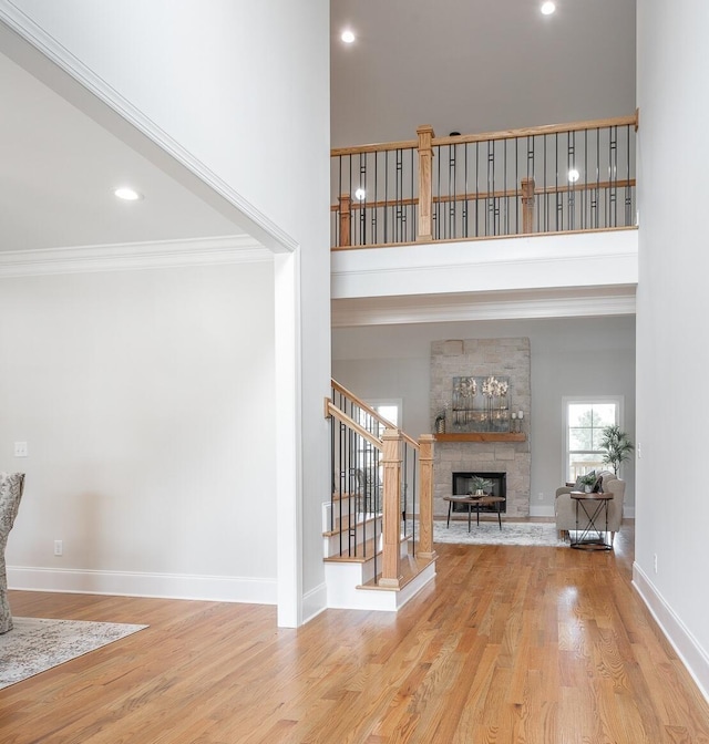 2212 Peterson Dr, Chattanooga, TN 37421 - unfurnished living room with a stone fireplace, stairway, wood finished floors, ornamental molding, and a towering ceiling
