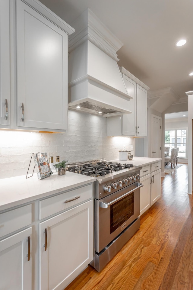 2212 Peterson Dr, Chattanooga, TN 37421 - kitchen featuring stainless steel stove, custom range hood, decorative backsplash, white cabinets, and recessed lighting
