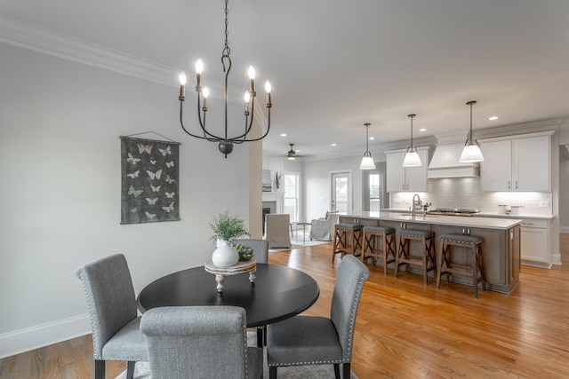 2212 Peterson Dr, Chattanooga, TN 37421 - dining space with crown molding, a ceiling fan, a fireplace, light wood-type flooring, and recessed lighting