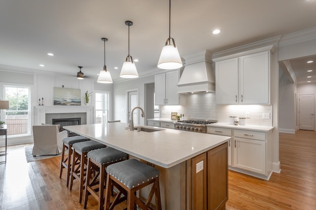 2212 Peterson Dr, Chattanooga, TN 37421 - kitchen with premium range hood, crown molding, decorative backsplash, an island with sink, and light wood-style flooring