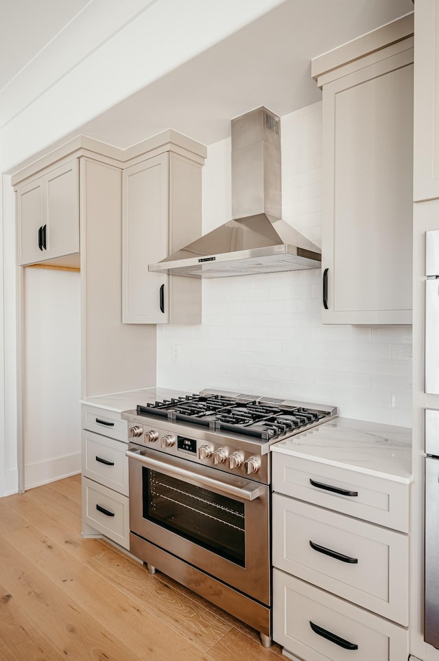 2013 Hector Dr, Thompsons Station, TN 37179 - kitchen featuring wall chimney range hood, gas stove, light countertops, tasteful backsplash, and light wood-style flooring