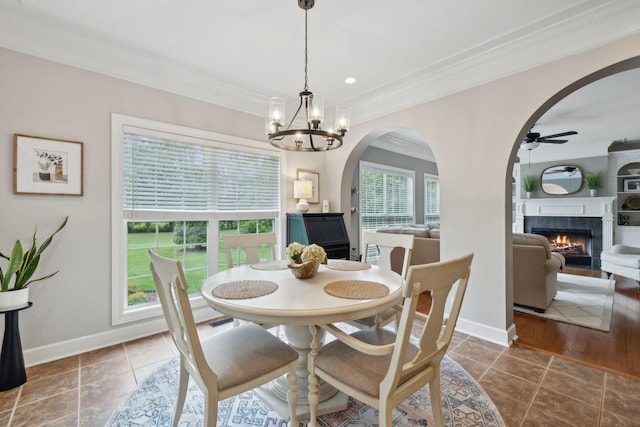 2335 Garrison Cv, Murfreesboro, TN 37130 - tiled dining area with ornamental molding, ceiling fan, a tiled fireplace, arched walkways, and a chandelier