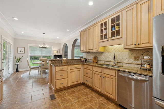2335 Garrison Cv, Murfreesboro, TN 37130 - kitchen featuring appliances with stainless steel finishes, a sink, light brown cabinets, arched walkways, and backsplash