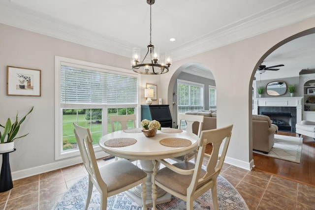 2335 Garrison Cv, Murfreesboro, TN 37130 - dining area featuring ornamental molding, a tile fireplace, arched walkways, a ceiling fan, and a chandelier