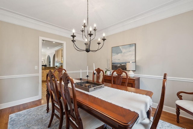 2335 Garrison Cv, Murfreesboro, TN 37130 - dining area featuring a chandelier, arched walkways, baseboards, ornamental molding, and wood finished floors