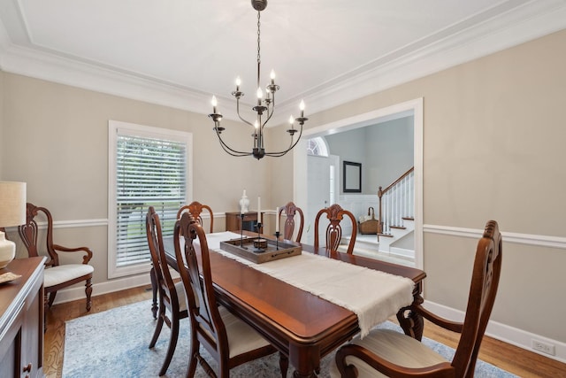2335 Garrison Cv, Murfreesboro, TN 37130 - dining room featuring a chandelier, ornamental molding, wood finished floors, stairway, and baseboards