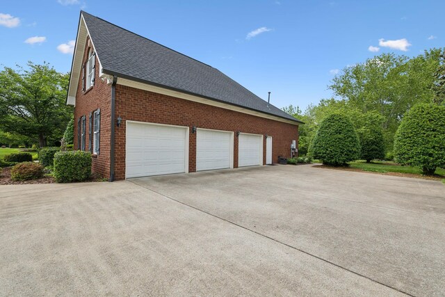 2335 Garrison Cv, Murfreesboro, TN 37130 - view of home's exterior with roof with shingles, a garage, brick siding, and driveway