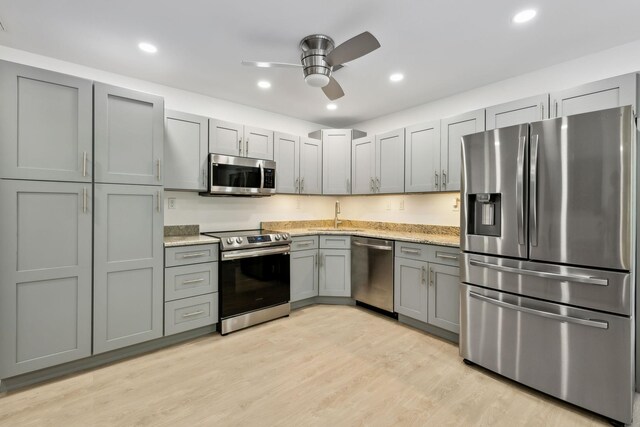 1840 Lick Creek Rd, Hartsville, TN 37074 - kitchen featuring stainless steel appliances, gray cabinets, ceiling fan, light wood-type flooring, and light stone counters