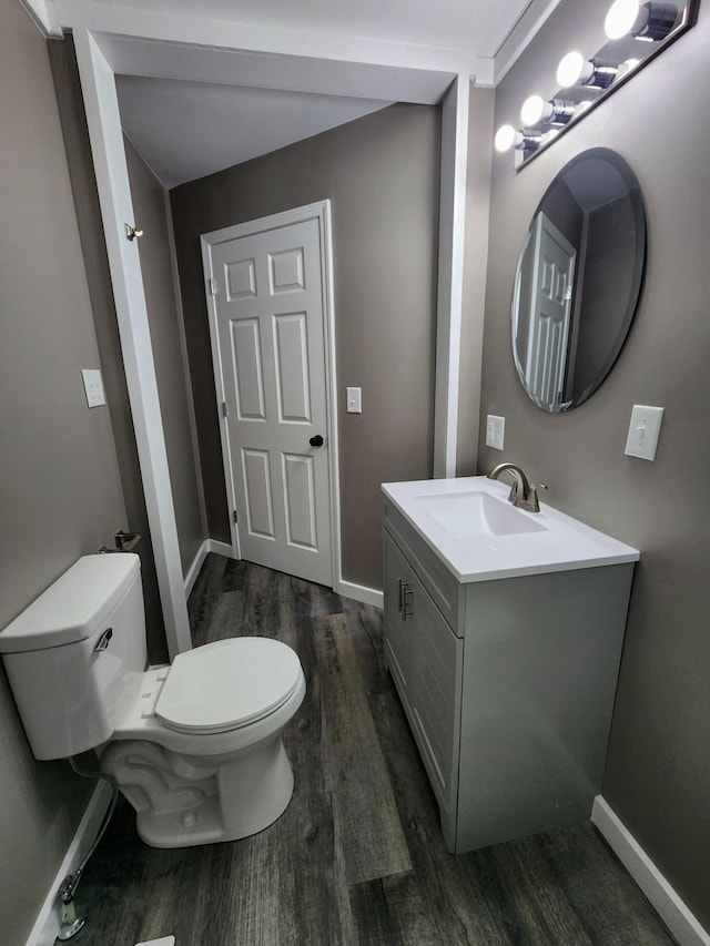 306 Johnson St, Lawrenceburg, TN 38464 - half bathroom featuring wood finished floors, toilet, vanity, and baseboards
