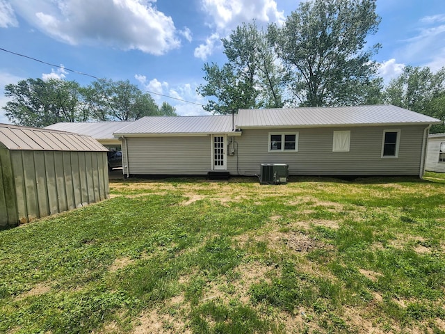 306 Johnson St, Lawrenceburg, TN 38464 - rear view of house with central AC, a yard, metal roof, a storage unit, and an outbuilding